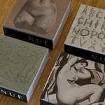 Four boxes with artistic designs and 'NUE' branding on a wooden surface