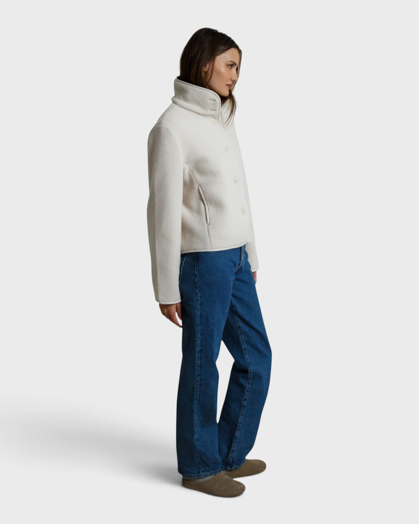 Model wearing a JONES + CO Tara sugar-colored sherpa button-front jacket with a high collar and side pockets.