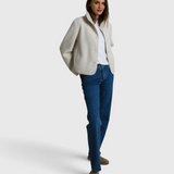 Model wearing a JONES + CO sugar white sherpa button-front jacket over a white tee and blue jeans