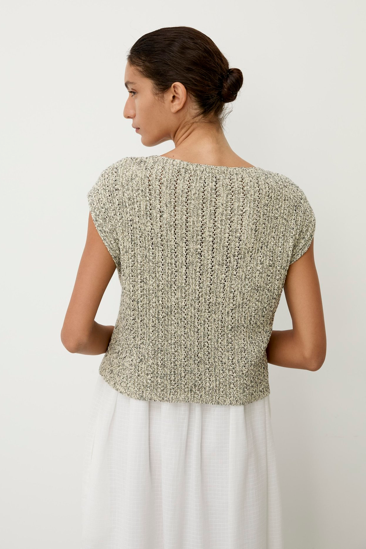 Woman wearing a textured green top against a white background