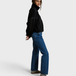 JONES + CO Tristan black sherpa half-zip pullover worn by a woman with blue jeans and slip-on shoes