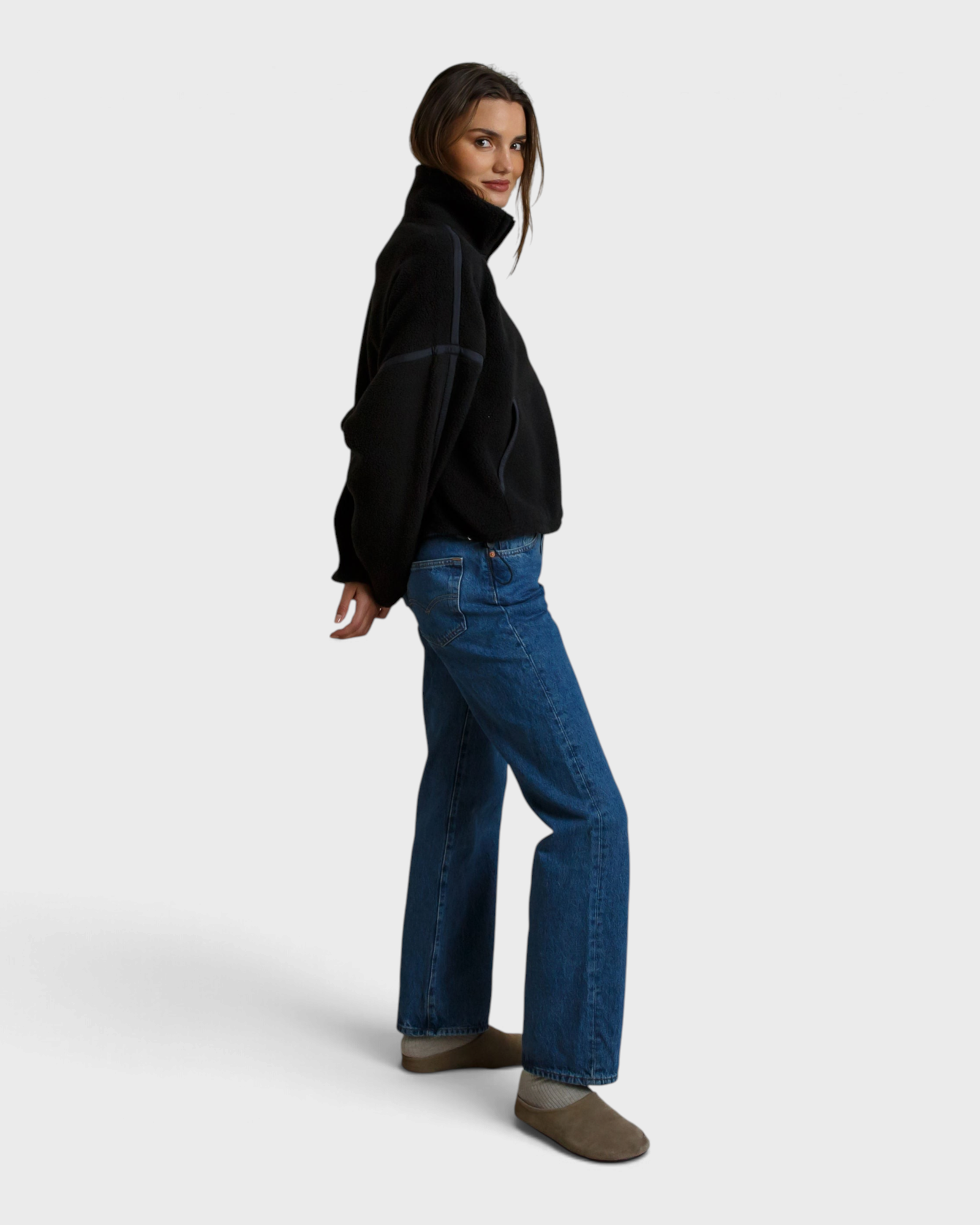 JONES + CO Tristan black sherpa half-zip pullover worn by a woman with blue jeans and slip-on shoes