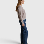 Model wearing a JONES + CO cloud gray textured Ziggy sweatshirt with blue jeans, side profile view.