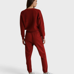Model wearing JONES + CO ruby red Ziggy sweatshirt and matching fleece joggers from the back