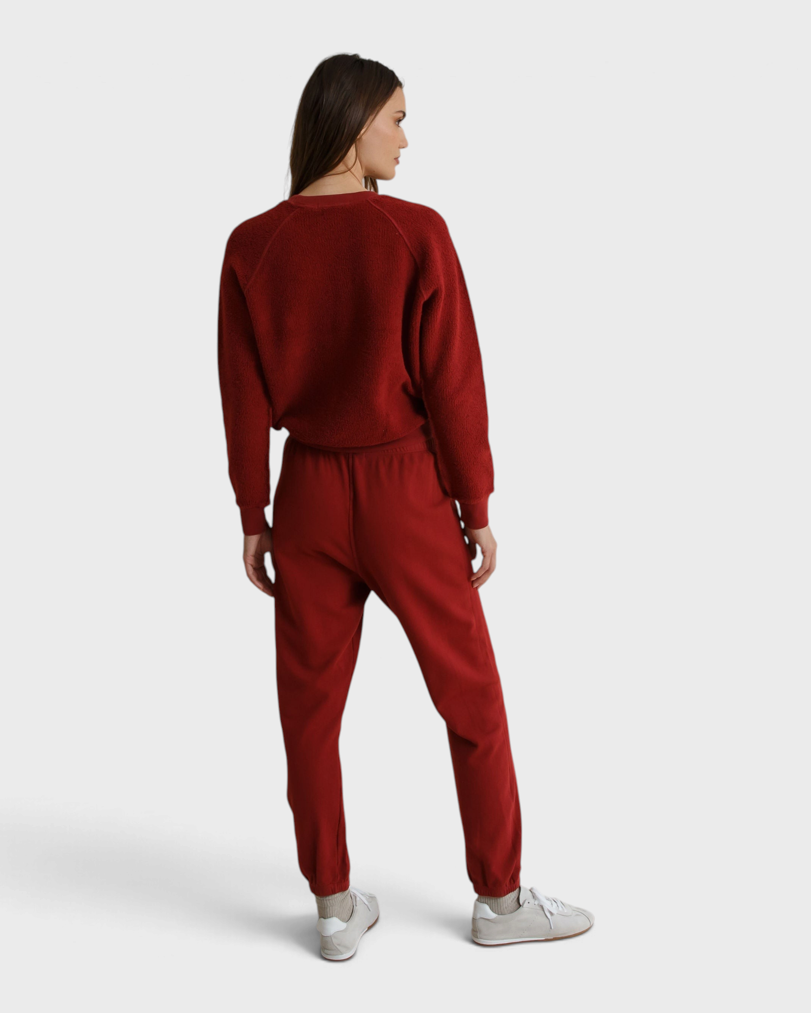 Model wearing JONES + CO ruby red Ziggy sweatshirt and matching fleece joggers from the back